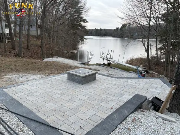 Paver patio with square fire pit overlooking the lake