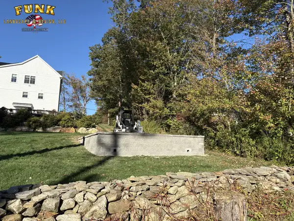 Low stone retaining wall bordering the back lawn