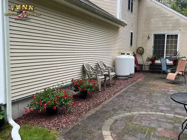 Paver patio with flower beds along the house, by Funk Landscape & Design