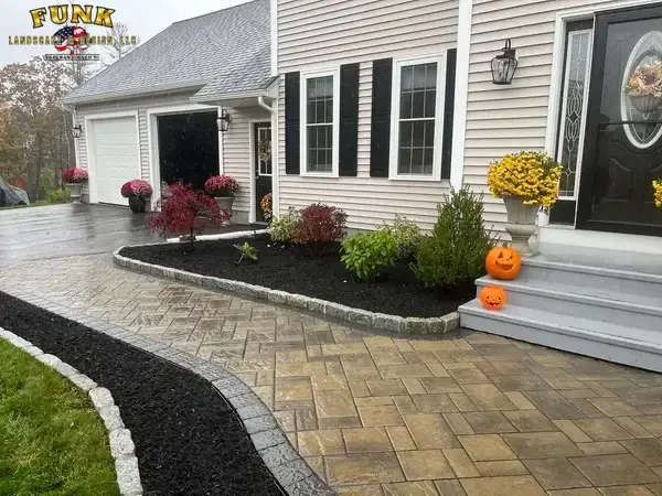 Fresh mulch beds with cobblestone edging and paver walkway installed in Worcester County, MA by Funk Landscape & Design