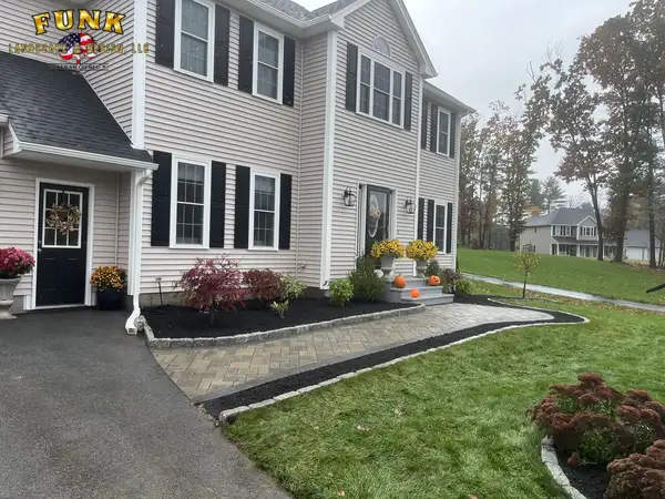 Full front-yard landscape installation with paver walkway, mulched planting beds, and new lawn by Funk Landscape & Design