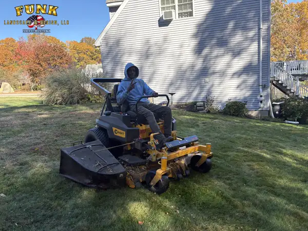 Crew member mowing a residential lawn on a zero-turn mower